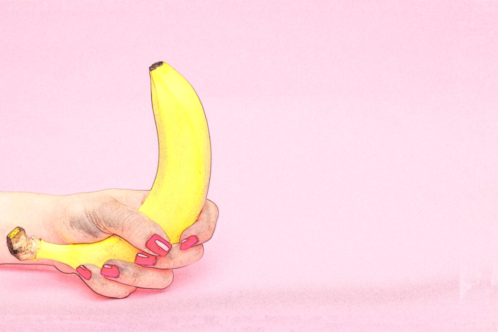 A female's hand holding a banana to depict the perfect blowjob.
